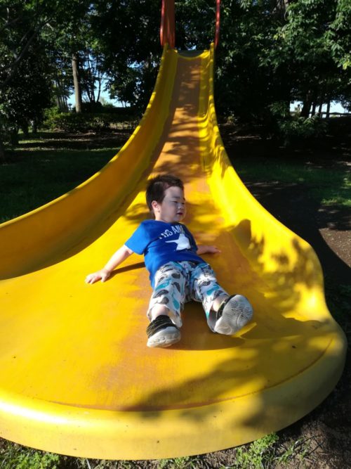 黄色い滑り台と筆者の息子の写真